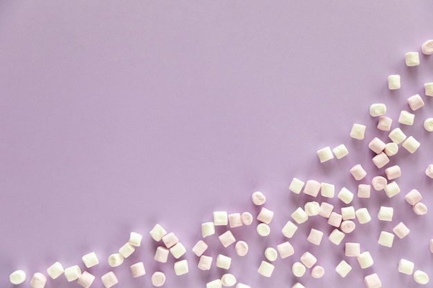 Foto hintergrund oder textur von rosa und weißen mini-marshmallows auf lila hintergrund mit freiem platz für text