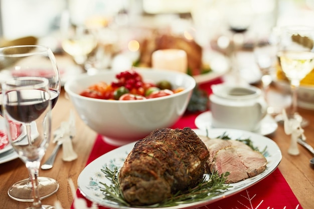 Hintergrund-Roastbeef und Thanksgiving-Essen auf dem Esstisch für Dinner-Party-Feier und Weihnachtsessen mit der Familie zu Hause Nahaufnahme von Schinkenfleisch und festlichem Festessen im feinen Speisesaal