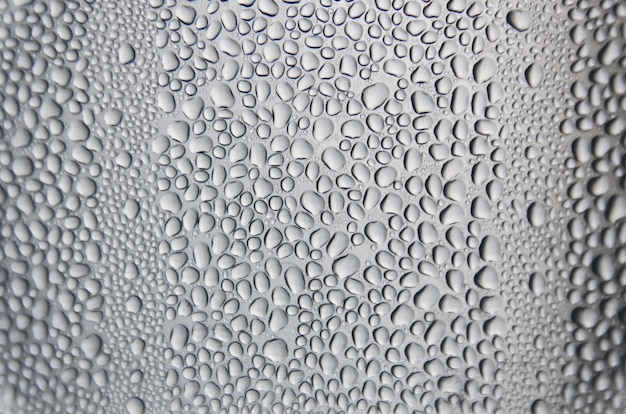 Hintergrund und Tapete durch regnerischen Tropfen und Wasser fällt auf Fensterglas.