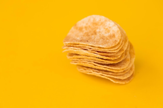 Hintergrund und Textur eines Haufens rotierender Kartoffelchips auf gelbem Hintergrund Ansicht von oben