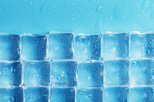 Hintergrund von Eiswürfeln mit Tropfen in blauer Farbe im Vollbildmodus