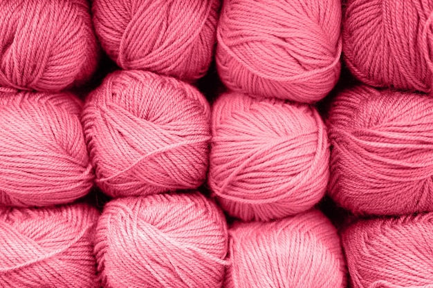 Hintergrund von Reihensträngen aus flauschigem Wollgarn zum Stricken von weichen, rot-rosa-violetten Farbtönen, die in Viva-Magenta-Trendfarbe des Jahres 2023 getönt sind