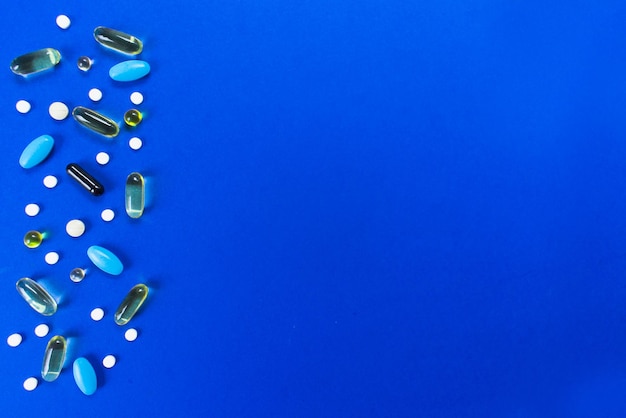 Hintergrund von Tabletten und Kapseln auf blauem KrankheitskonzeptPlatz kopieren