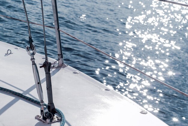 Hintergrund-Yachting-Fragment des Rumpfes eines Segelbootes mit Takelage vor dem Hintergrund des Wassers