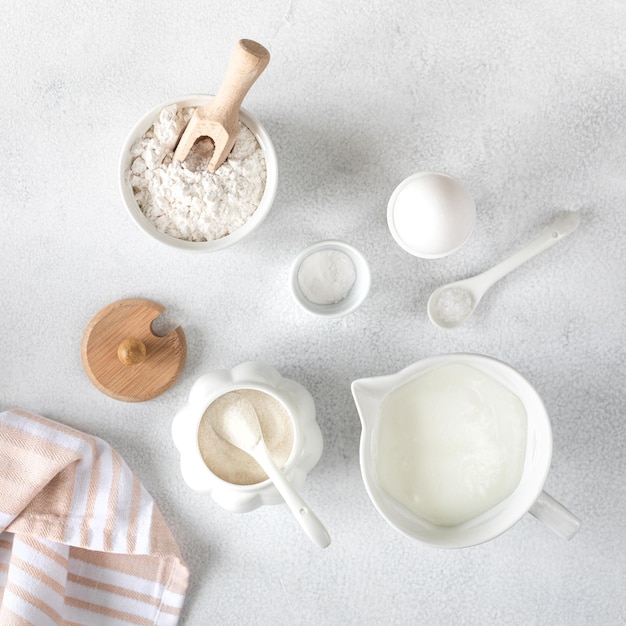 Hintergrund zum Backen von Kuchen und Donuts Backzutaten Mehl Ei Milch Zucker auf weißem Hintergrund Ansicht von oben Quadrat