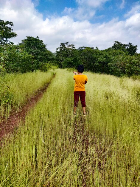 Foto hintergrundansicht des jungen auf dem feld gegen den himmel