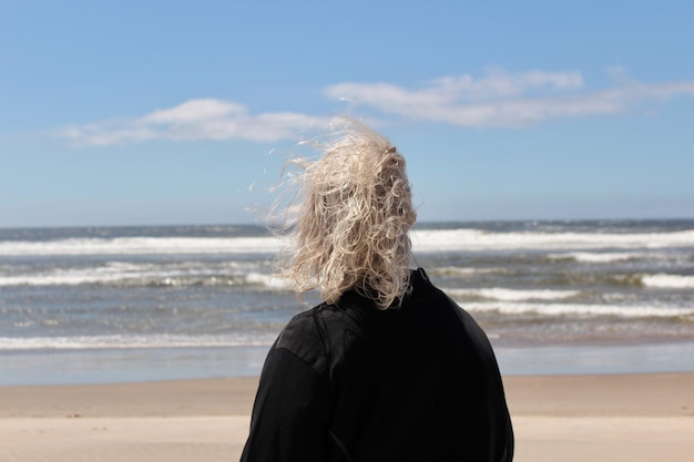 Hintergrundansicht einer Frau am Strand gegen den Himmel