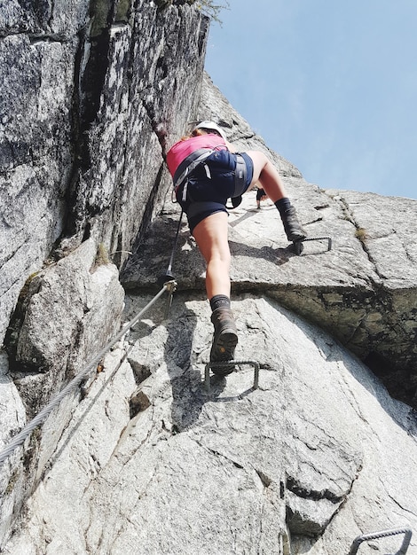 Hintergrundansicht einer Frau beim Bergsteigen an der via ferrata merano heini-holzer-klettersteig