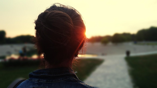 Hintergrundansicht einer Frau beim Sonnenuntergang