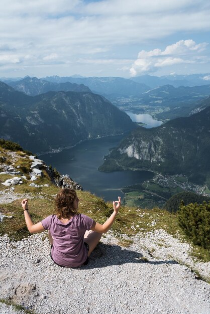 Foto hintergrundansicht einer frau, die am berg am see sitzt