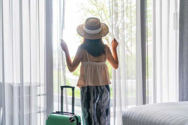 Hintergrundansicht einer Frau, die am Fenster steht