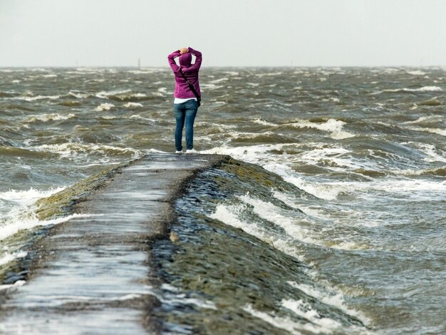 Foto hintergrundansicht einer frau, die am ozean steht