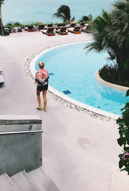 Hintergrundansicht einer Frau, die am Schwimmbad geht