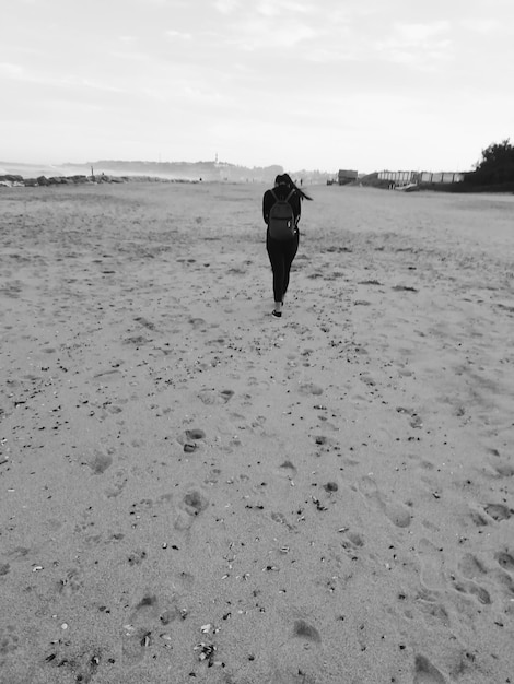 Foto hintergrundansicht einer frau, die am strand spazieren geht