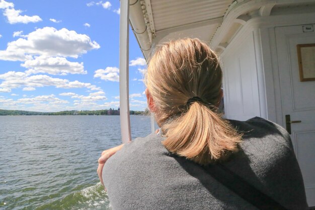 Foto hintergrundansicht einer frau, die auf das meer gegen den himmel schaut