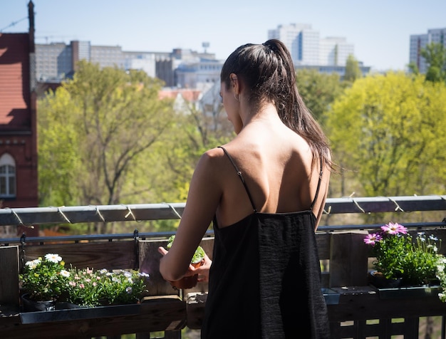 Hintergrundansicht einer Frau, die auf dem Balkon steht