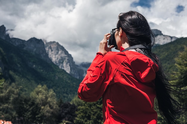 Hintergrundansicht einer Frau, die auf dem Berg gegen den Himmel steht
