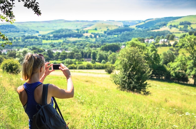 Hintergrundansicht einer Frau, die auf dem Feld fotografiert