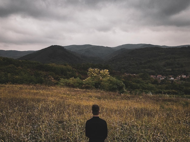 Hintergrundansicht einer Frau, die auf dem Feld geht