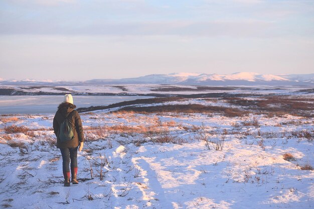 Foto hintergrundansicht einer frau, die auf schneebedecktem land steht