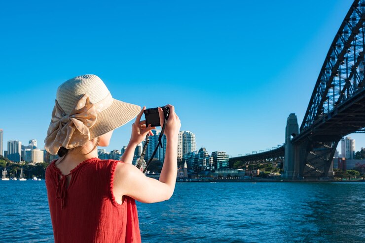 Foto hintergrundansicht einer frau, die die sydney harbour bridge vor klarem himmel fotografiert