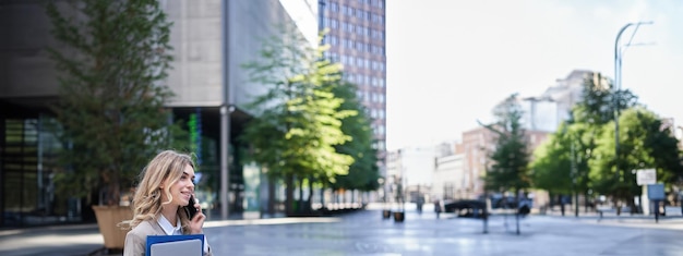 Foto hintergrundansicht einer frau, die ein handy in der stadt benutzt