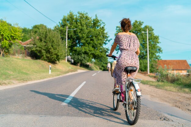 Foto hintergrundansicht einer frau, die fahrrad auf der straße fährt