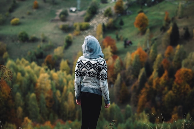 Hintergrundansicht einer Frau, die gegen Bäume steht