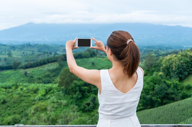 Hintergrundansicht einer Frau, die gegen Berge fotografiert