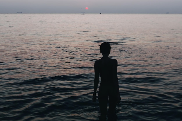 Hintergrundansicht einer Frau, die im Meer steht