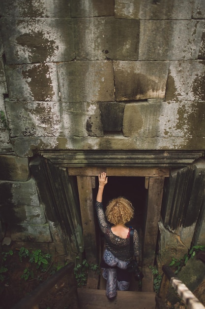 Foto hintergrundansicht einer frau, die in eine alte ruine eintritt