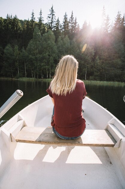Hintergrundansicht einer Frau, die in einem Boot auf einem See sitzt
