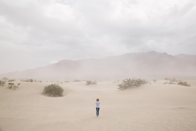 Hintergrundansicht einer Frau, die während eines Sandsturms im Todestal gegen den Himmel steht