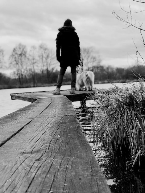 Foto hintergrundansicht einer frau mit einem hund auf der promenade.