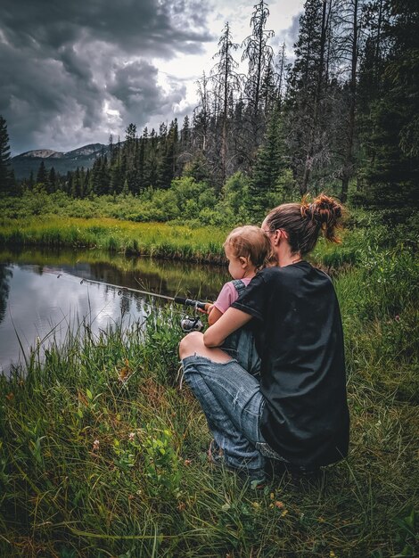 Foto hintergrundansicht einer frau und eines kindes, die in den bergen von montana angeln