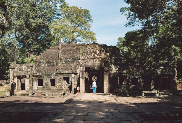Hintergrundansicht einer mittleren erwachsenen Frau, die im Ankor-Wat-Tempel spazieren geht