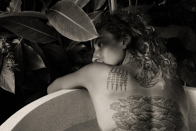 Hintergrundansicht einer topless-Frau mit Tattoo auf dem Rücken