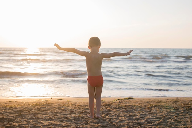 Hintergrundansicht eines Jungen, der am Strand steht