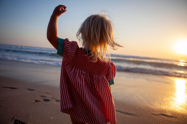 Foto hintergrundansicht eines kindes, das am strand gegen den himmel rennt