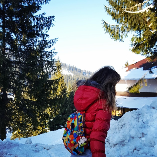 Foto hintergrundansicht eines kindes, das auf einer schneebedeckten landschaft steht