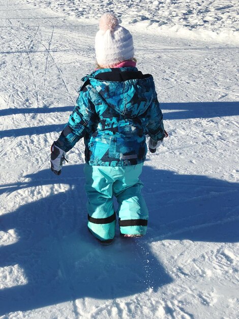 Foto hintergrundansicht eines mädchens, das auf einem schneebedeckten feld läuft