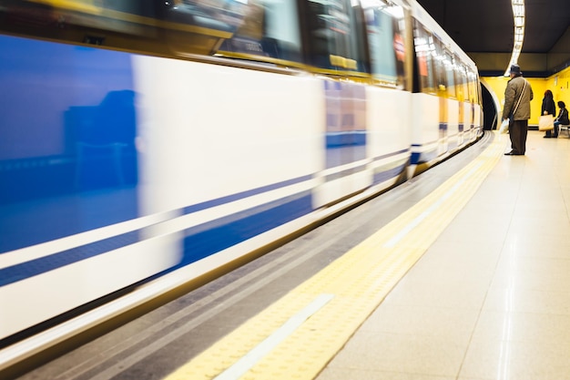 Hintergrundansicht eines Mannes, der am U-Bahnhof am Zug steht