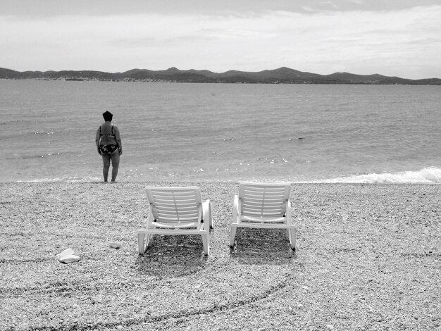 Foto hintergrundansicht eines mannes, der auf das meer schaut