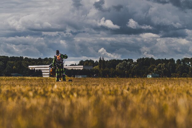 Foto hintergrundansicht eines mannes, der auf dem feld gegen den himmel arbeitet