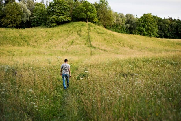 Foto hintergrundansicht eines mannes, der auf dem feld geht