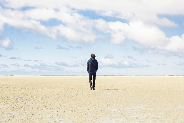 Foto hintergrundansicht eines mannes, der auf der wüste gegen den himmel steht