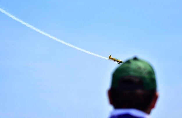 Foto hintergrundansicht eines mannes, der auf eine flugshow schaut