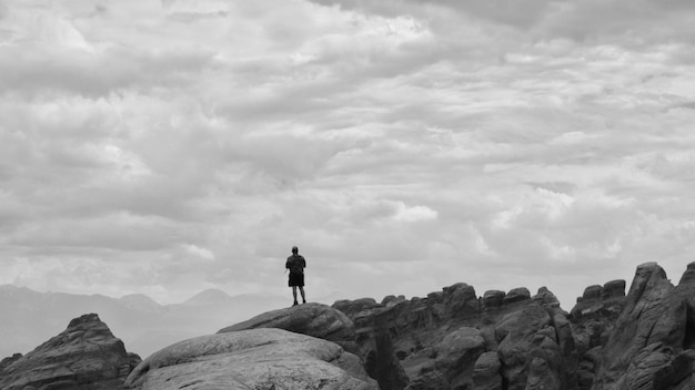 Foto hintergrundansicht eines mannes, der auf einem felsen gegen den himmel steht