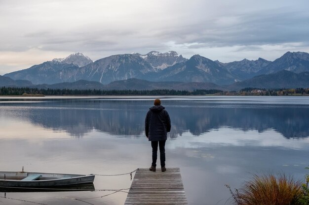 Hintergrundansicht eines Mannes, der auf einem See gegen Berge steht