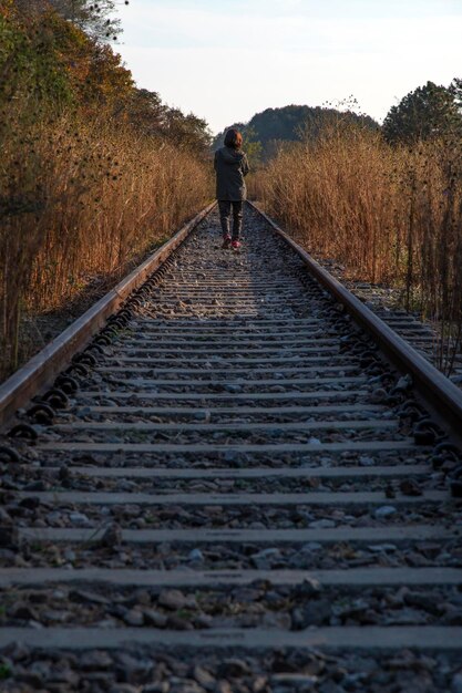 Foto hintergrundansicht eines mannes, der auf einer eisenbahnstrecke geht